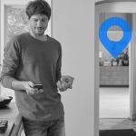 Man using smartphone and holding bell pepper in kitchen